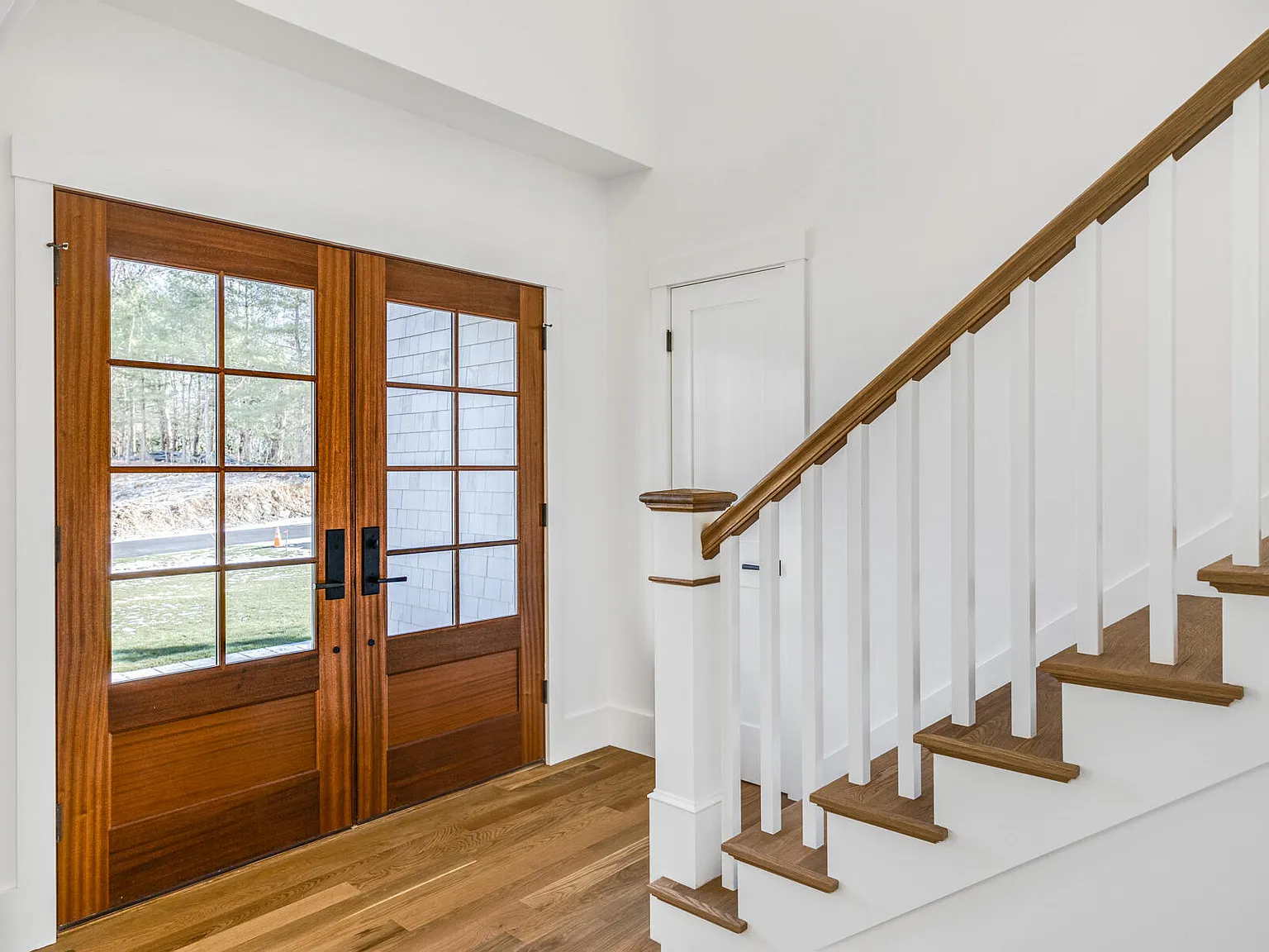 Entry foyer — mahogany double doors, white oak staircase with oak treads