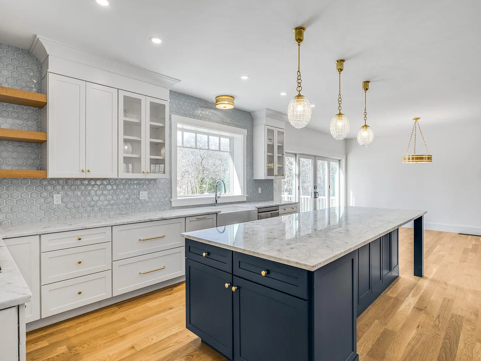 Chef's kitchen — navy island, marble countertops, brass pendants, hex tile backsplash