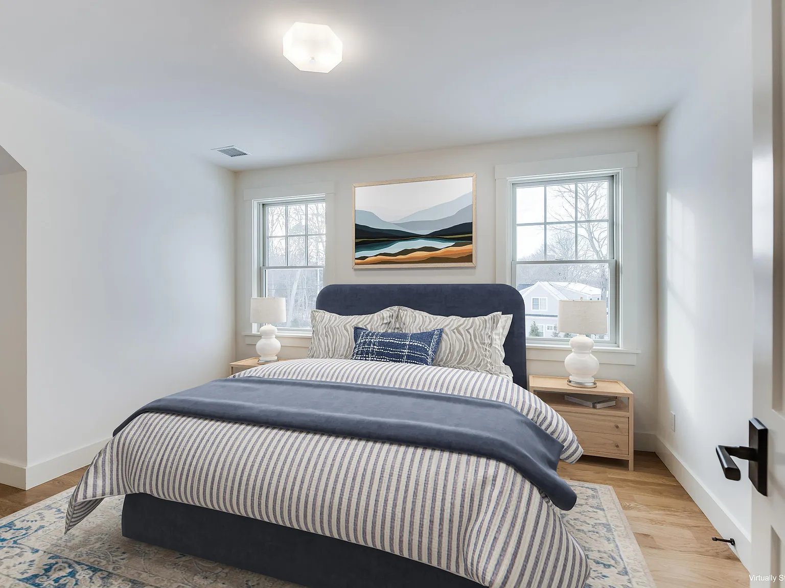Guest bedroom — navy headboard, coastal artwork, Andersen windows